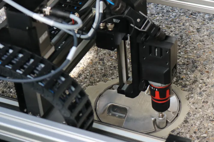 Automated screwdriving unit of the ScrewRover precisely tightening a runway light screw using AI and a Nanotec drive system.