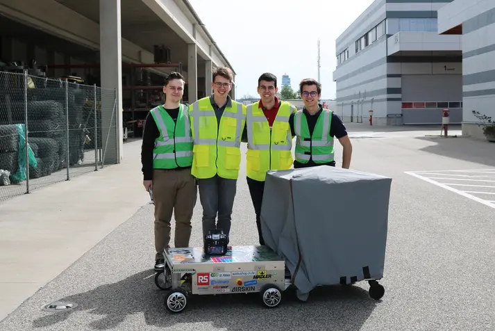 Four students from HTL Rennweg present the ScrewRover for screw maintenance on the airfield — a remotely controlled maintenance robot with a Nanotec motor and planetary gearbox.