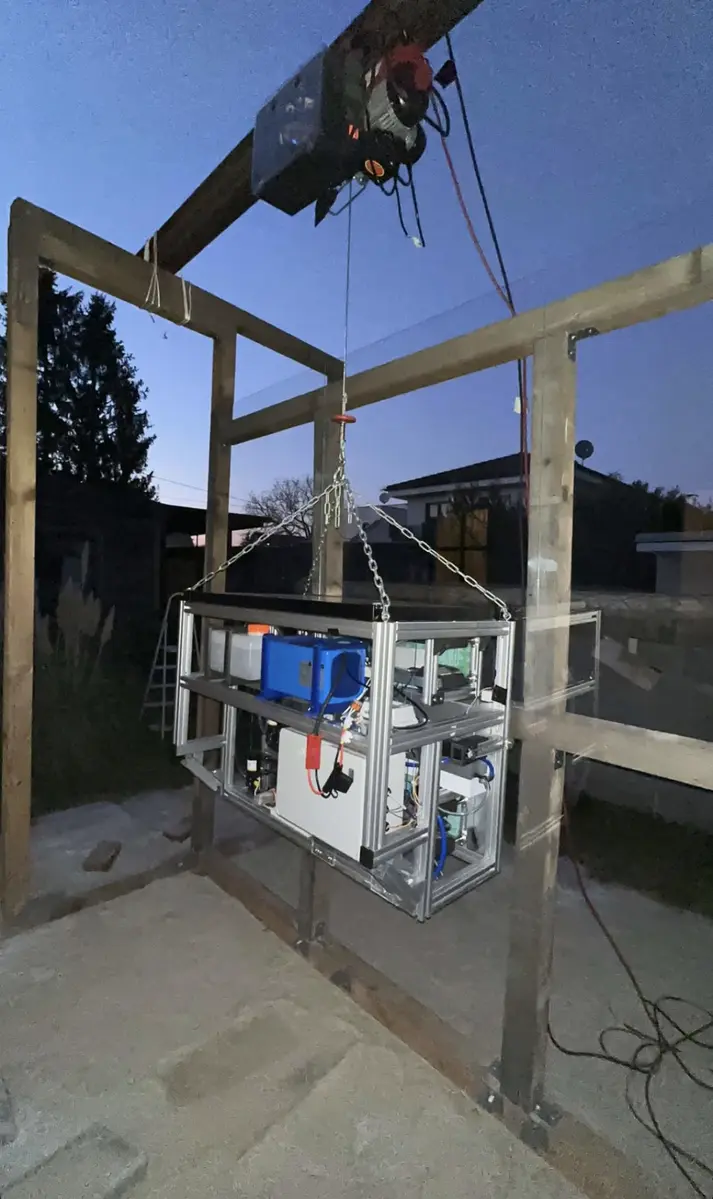 SkyScrubber system suspended from a crane during automated window cleaning tests, using Nanotec motors to control vacuum chambers and cleaning mechanics.